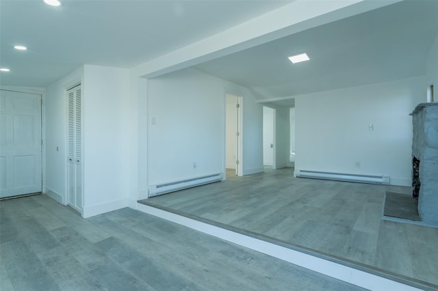 empty room with light hardwood / wood-style floors and a baseboard radiator