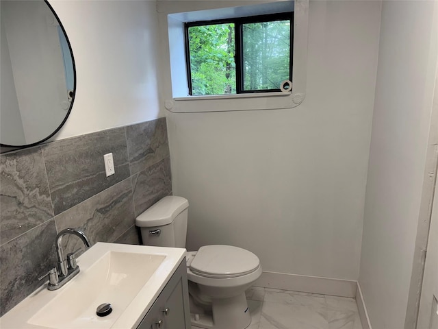 3 Brookside Trl, Monroe, NY 10950 - half bathroom featuring tile walls, marble finish floors, toilet, vanity, and a wainscoted wall