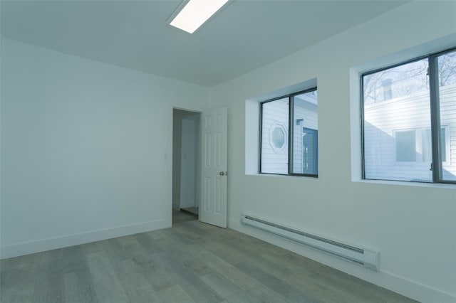 3 Brookside Trl, Monroe, NY 10950 - empty room with a baseboard heating unit, wood finished floors, and baseboards