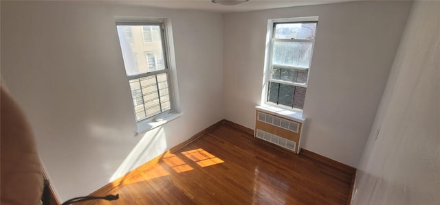 unfurnished room with radiator and dark hardwood / wood-style flooring