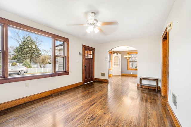 entrance foyer with ceiling fan with notable chandelier and dark hardwood / wood-style floors