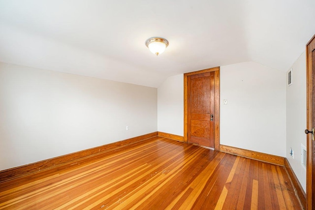 interior space featuring wood-type flooring and vaulted ceiling