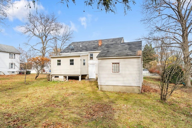 rear view of property with a lawn