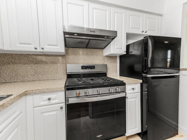 kitchen featuring white cabinets, black fridge, stainless steel range with gas cooktop, tasteful backsplash, and extractor fan