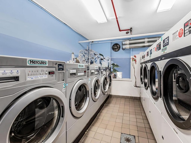 laundry room with washer and clothes dryer and light tile patterned flooring