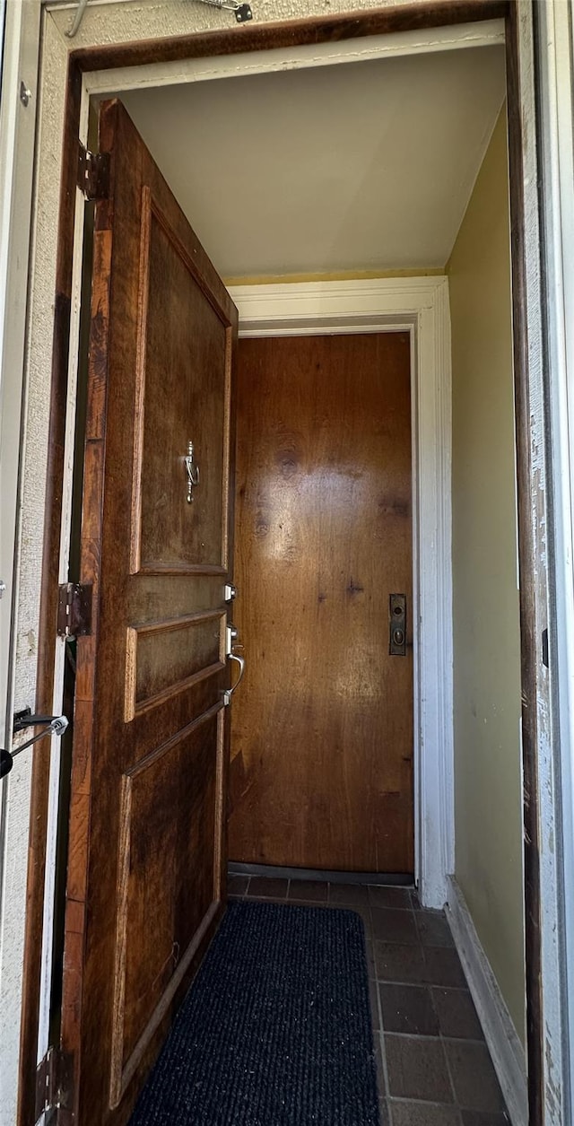 doorway featuring dark tile patterned floors