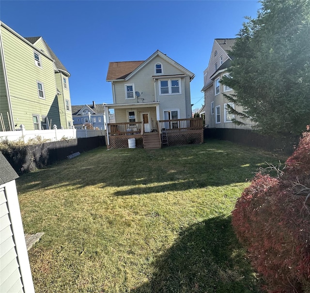 rear view of property with a yard and a deck