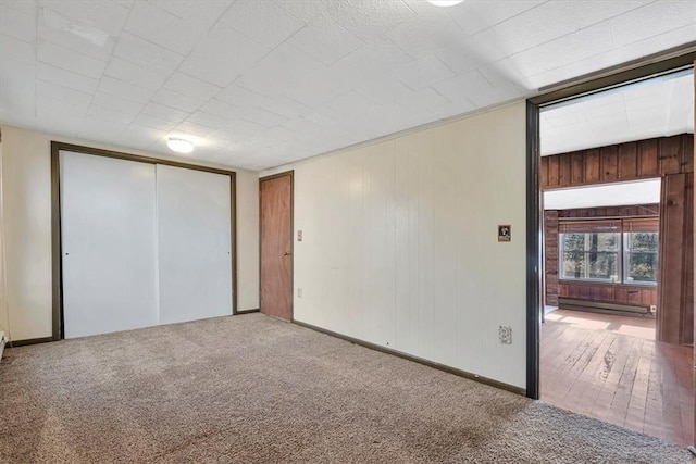 unfurnished room featuring wood-type flooring and a baseboard heating unit