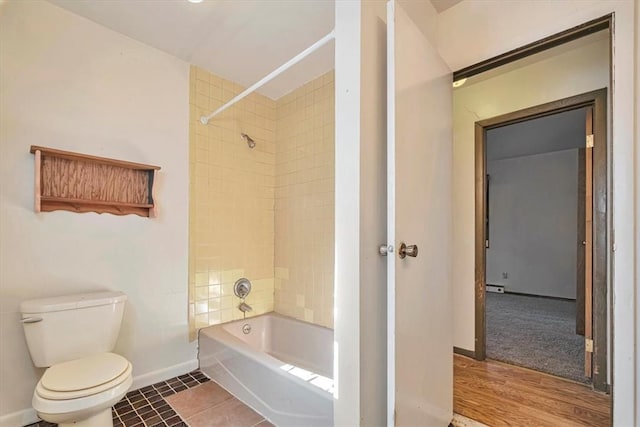 bathroom featuring tiled shower / bath combo, hardwood / wood-style flooring, and toilet