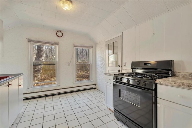 kitchen featuring black gas range, light tile patterned flooring, a baseboard heating unit, lofted ceiling, and white cabinets