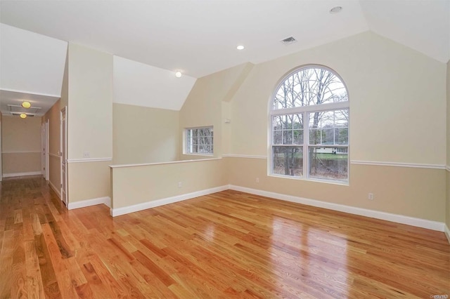 empty room with light hardwood / wood-style flooring and lofted ceiling