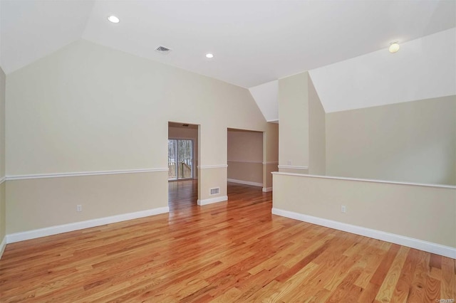 spare room with vaulted ceiling and light hardwood / wood-style flooring