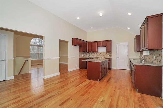 kitchen featuring a center island, tasteful backsplash, light hardwood / wood-style flooring, and sink