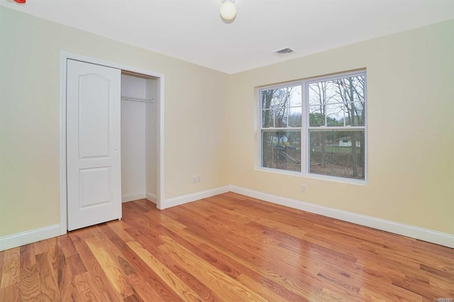 unfurnished bedroom with light hardwood / wood-style floors and a closet