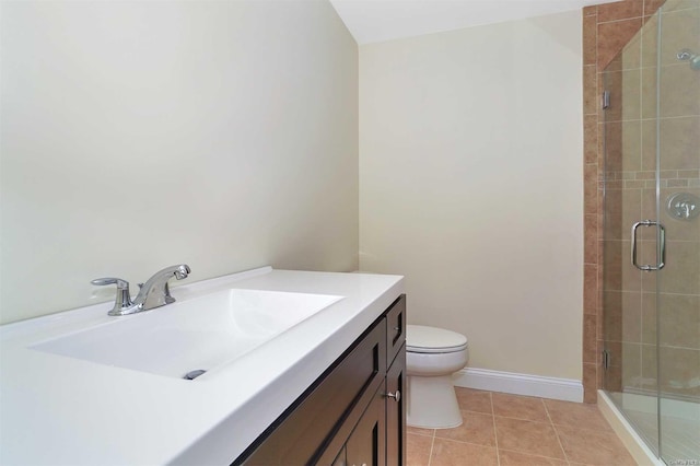 bathroom featuring toilet, vanity, tile patterned floors, and a shower with shower door