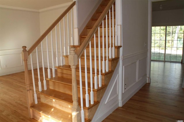 stairway featuring crown molding and hardwood / wood-style flooring