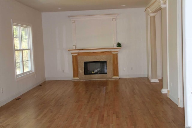 unfurnished living room featuring plenty of natural light and hardwood / wood-style floors