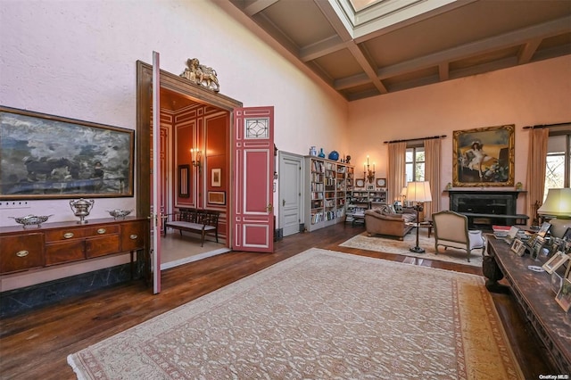 living area featuring beamed ceiling, plenty of natural light, dark wood-type flooring, and coffered ceiling