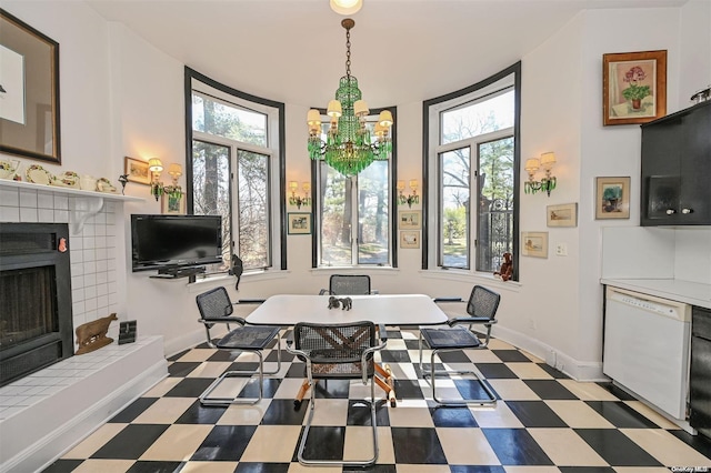 dining space with a fireplace and a notable chandelier