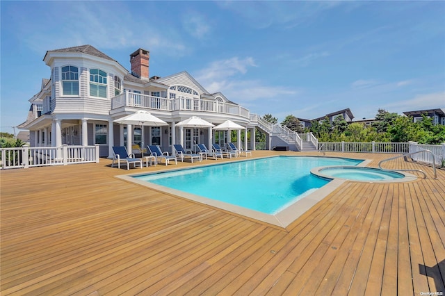 view of pool with an in ground hot tub and a wooden deck