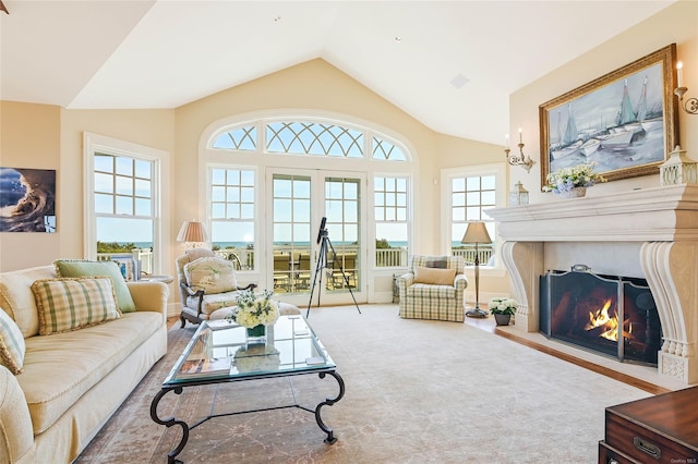 carpeted living room with high vaulted ceiling and french doors