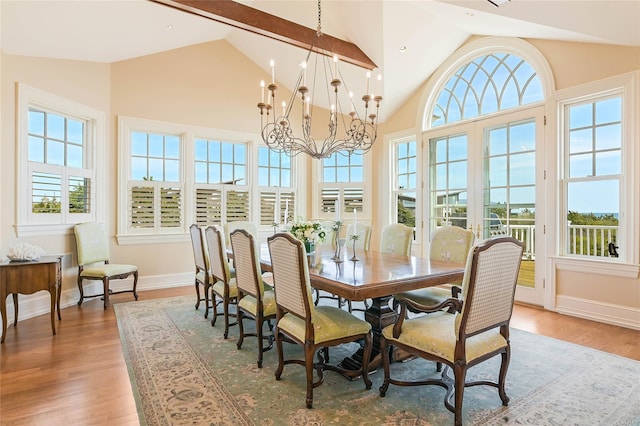 dining space featuring french doors, high vaulted ceiling, a chandelier, and hardwood / wood-style floors