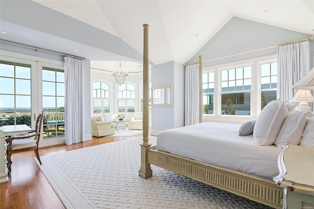 bedroom featuring hardwood / wood-style floors, a notable chandelier, access to outside, and high vaulted ceiling