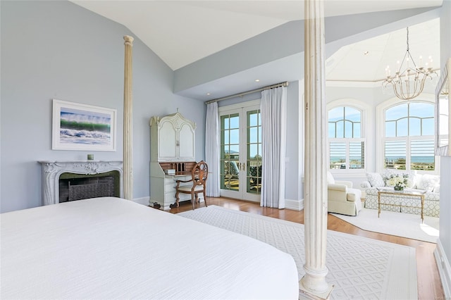 bedroom featuring high vaulted ceiling, access to outside, a notable chandelier, hardwood / wood-style flooring, and a high end fireplace