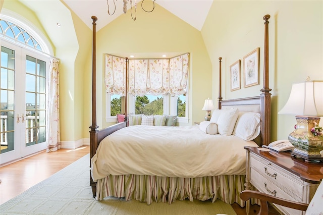 bedroom with multiple windows, access to outside, light hardwood / wood-style floors, and french doors