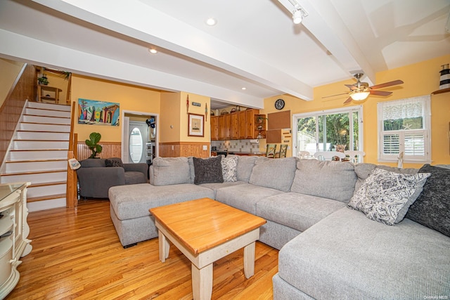 living room with beamed ceiling, light hardwood / wood-style floors, and ceiling fan