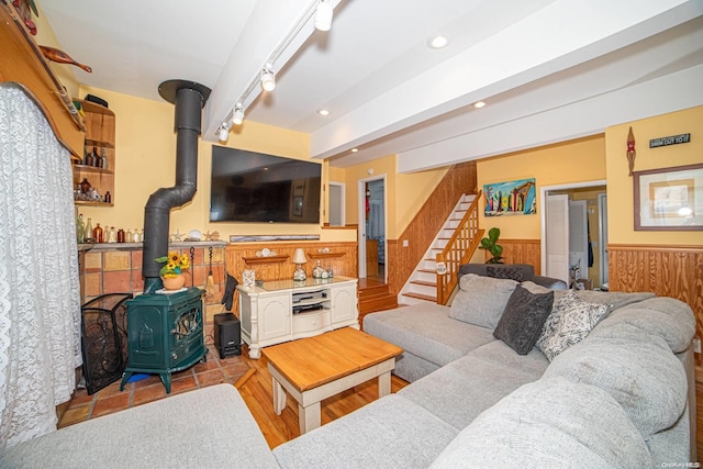 living room featuring light hardwood / wood-style floors, a wood stove, and rail lighting