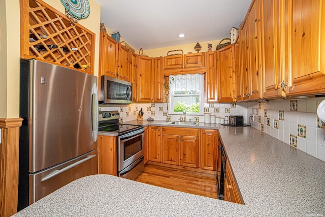 kitchen featuring stainless steel appliances, tasteful backsplash, and sink