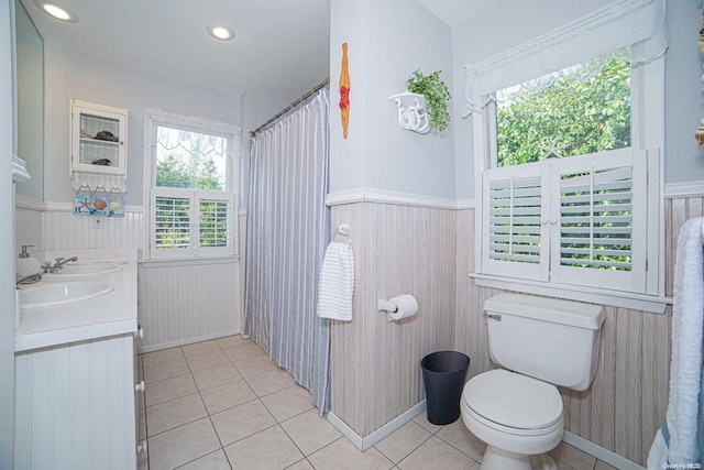 bathroom featuring tile patterned flooring, vanity, toilet, and curtained shower