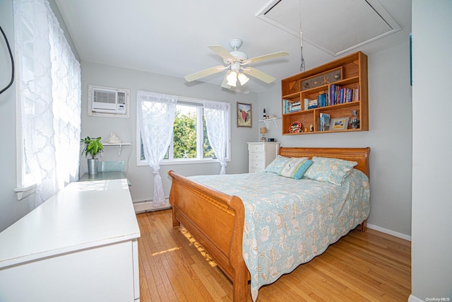 bedroom with an AC wall unit, ceiling fan, light hardwood / wood-style floors, and baseboard heating