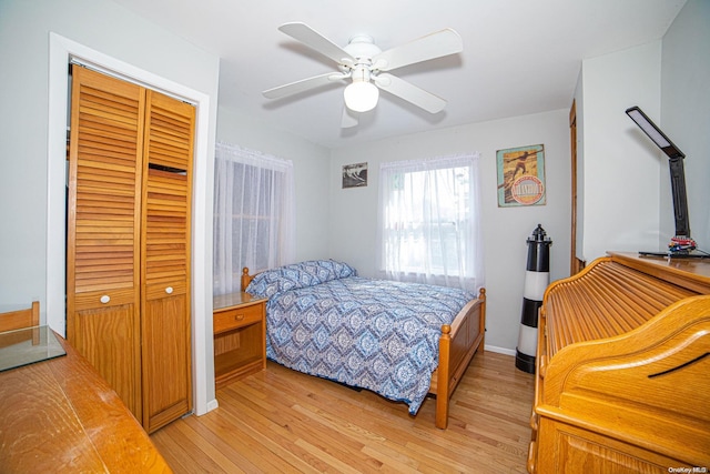 bedroom featuring light hardwood / wood-style flooring, a closet, and ceiling fan