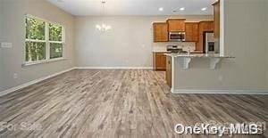 kitchen featuring a kitchen breakfast bar, kitchen peninsula, stainless steel appliances, and hardwood / wood-style flooring