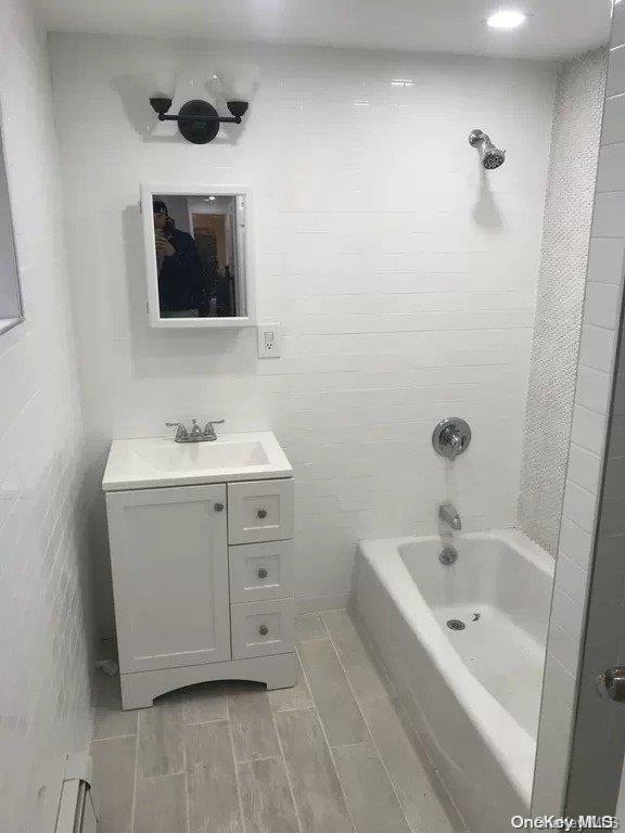 bathroom with vanity and tiled shower / bath combo