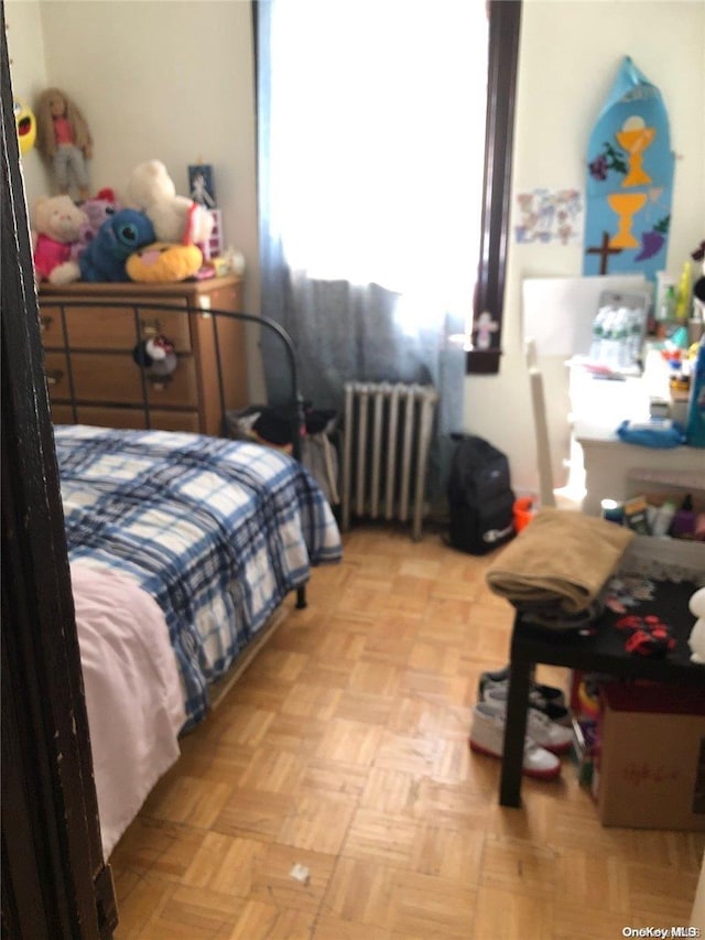 bedroom with radiator and light parquet floors