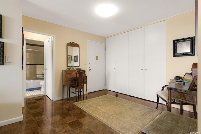 bedroom with ensuite bath and dark parquet floors