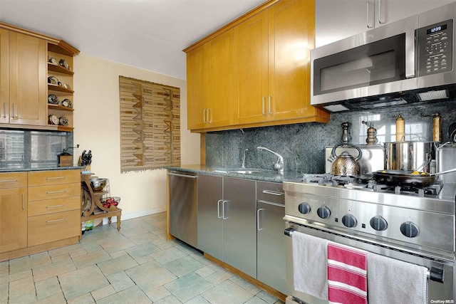 kitchen with sink, backsplash, stainless steel appliances, and dark stone countertops