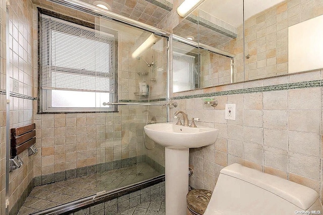 bathroom featuring sink, toilet, tile walls, and walk in shower