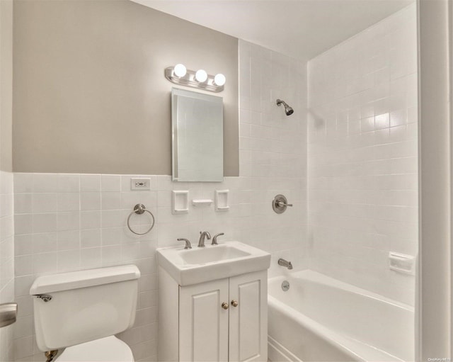 full bathroom with tiled shower / bath combo, toilet, tile walls, and vanity