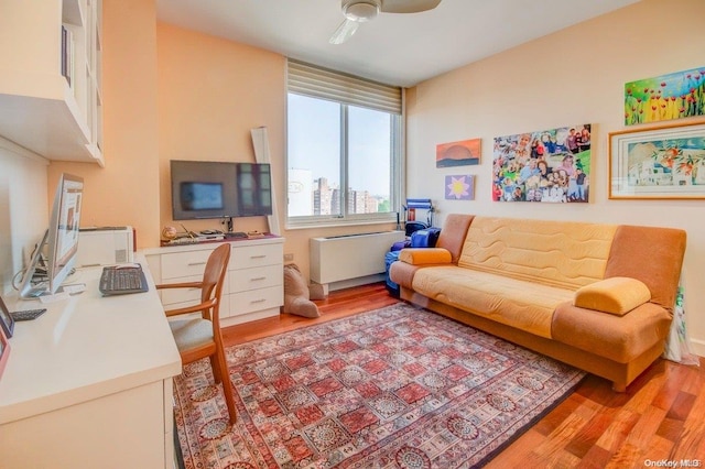 office space featuring radiator, ceiling fan, and light hardwood / wood-style flooring