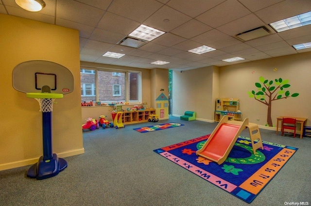 game room with a paneled ceiling and carpet