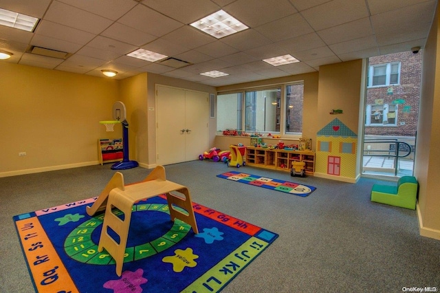 recreation room with carpet floors and a paneled ceiling