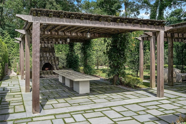 view of patio / terrace with an outdoor stone fireplace and a pergola