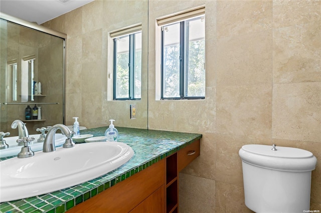 bathroom with vanity, toilet, and tile walls