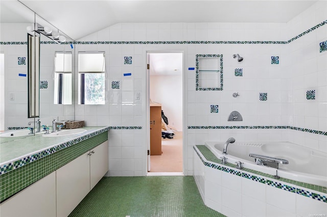 bathroom featuring tile patterned flooring, tiled tub, vaulted ceiling, vanity, and tile walls