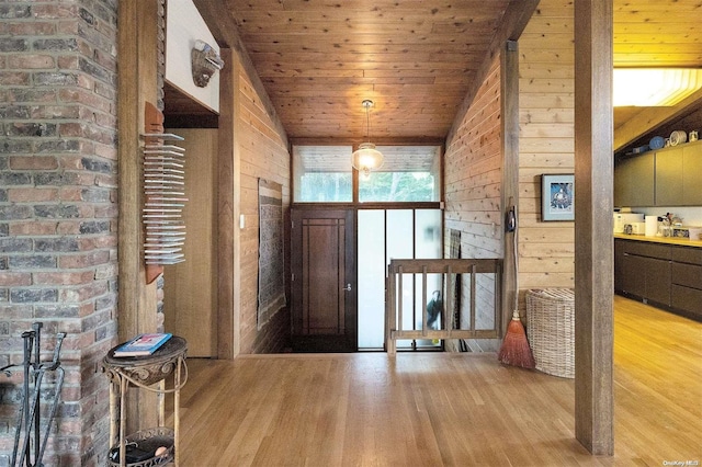 entryway with wooden ceiling, light hardwood / wood-style flooring, lofted ceiling, and wood walls