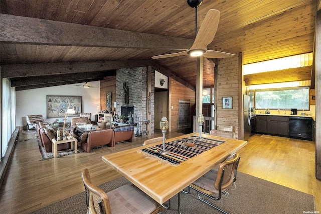 dining space featuring wood-type flooring, lofted ceiling with beams, a wood stove, and wooden ceiling